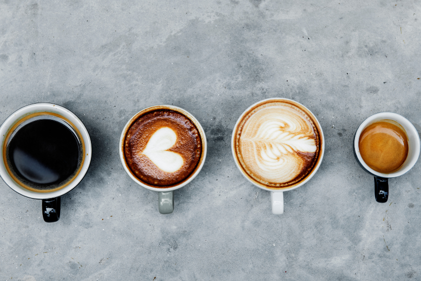 Różne rodzaje kawy w filiżankach na szarym tle