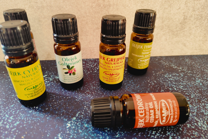 olejki-eteryczne-bamer-naturalne-cytrynowy-golteriowy-grejpfrutowy-tymianowy-i-cedrowy-w-szklanych-buteleczkach-na-niebiesko-czarnym-rozswietlonym-tle