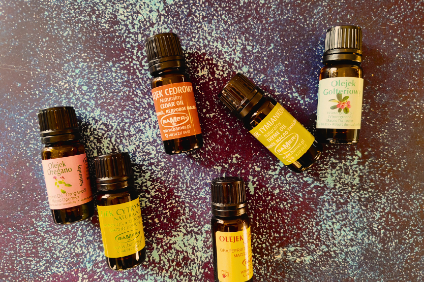 olejki-eteryczne-bamer-naturalne-oregano-cedrowy-tymianowy-golteriowy-cytrynowy-grejpfrutowy-w-szklanych-buteleczkach-na-niebiesko-fioletowym-tle-z-rozswietleniem