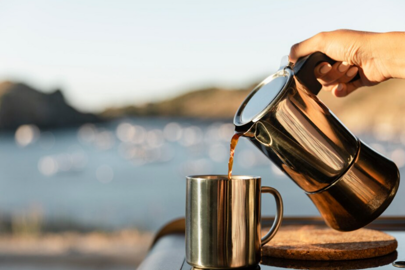 Nalewanie kawy z kawiarki do stalowego kubka