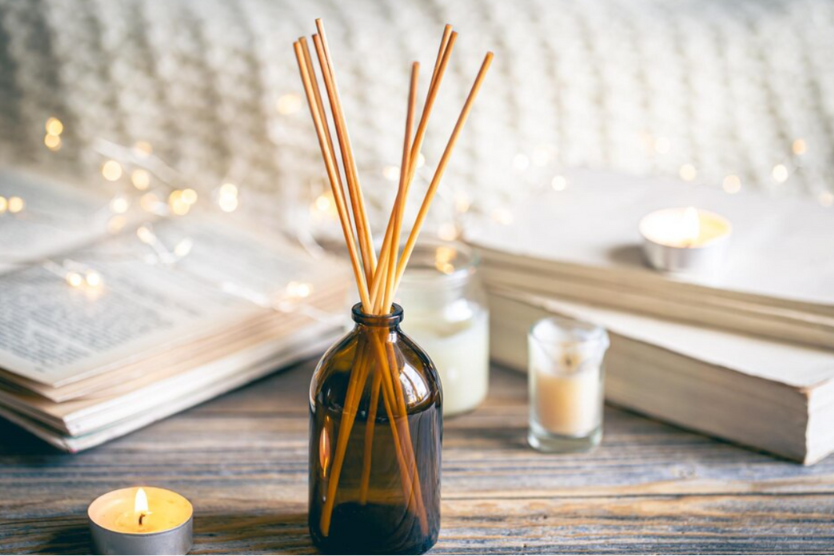 Patyczki zapachowe, świece i otwarta książka – aromatyczny relaks