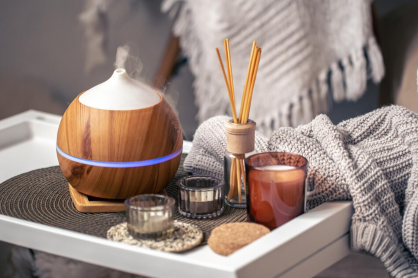 Dyfuzor zapachowy, świeca i patyczki zapachowe w przytulnym domowym wnętrzu